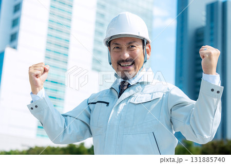 ガッツポーズする作業服の男性 131885740