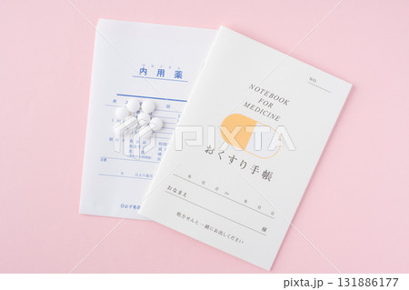 ピンク色の背景におくすり手帳と薬 131886177