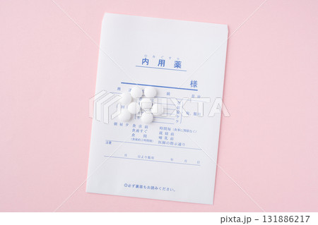 ピンク色の背景に薬袋と錠剤 131886217