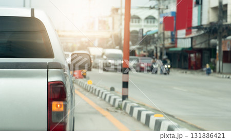 Rear side of pickup car with turn on right signal. Median strip painted in a mysterious White and black color. Opposite road with cars prepare to drive after green light open. Environment in the city, 131886421