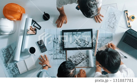 Top view of manager looking at plan while designer hold blueprint. Alimentation. 131887781