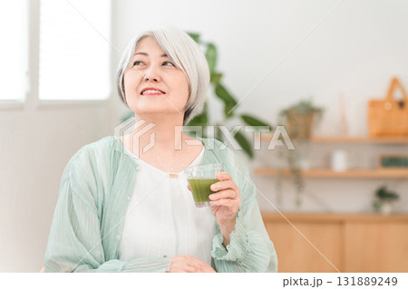 健康のため青汁・グリーンスムージー・野菜ジュースを飲むシニア女性 131889249