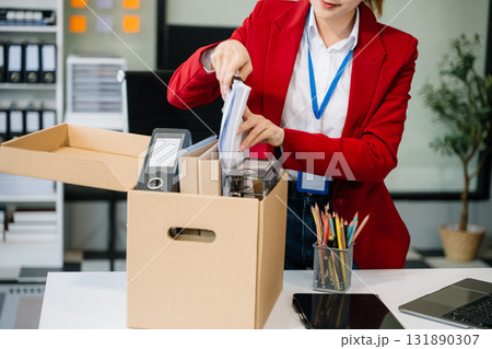 Happy and excited young beautiful Asian woman office worker celebrating her resignation, carrying her personal stuff. Happy and excited young beautiful Asian woman office worker celebrating her resignation, carrying her personal stuff. 131890307