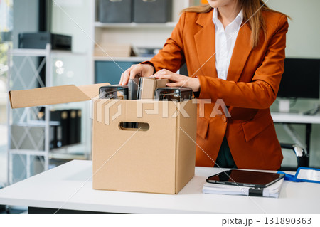 Happy and excited young beautiful Asian woman office worker celebrating her resignation, carrying her personal stuff. Happy and excited young beautiful Asian woman office worker celebrating her resignation, carrying her personal stuff. 131890363