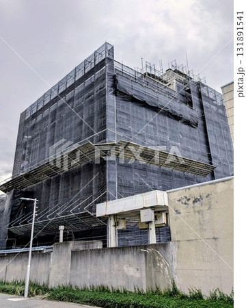 建物の外壁に工事の足場とシートをかけた風景 建物の外壁に工事の足場とシートをかけた風景 131891541