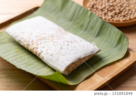 Raw tempeh made from fermented soybeans wrapped by banana leaf, Traditional Indonesian food Raw tempeh made from fermented soybeans wrapped by banana leaf, Traditional Indonesian food 131891849