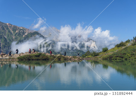 湧きたつ雲をバックに歩く人が映る八方池【八方尾根】長野県白馬村・9月 131892444