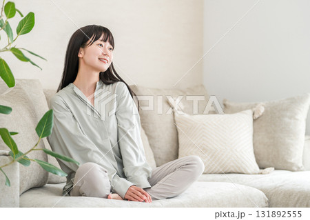 自宅のリビングでくつろぐ笑顔の若いアジア人女性 131892555