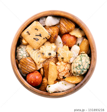 Japanese rice crackers, in wooden bowl. Assorted varieties of Arare crackers made from rice flour, baked and brushed with soy sauce and vinegar to create a smooth texture, some sprinkled with seaweed. 131893216