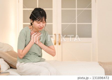 ベッドの上で胸を苦しがる急病の女性(苦しい・発作・心筋梗塞・心臓発作・動悸・狭心症) ベッドの上で胸を苦しがる急病の女性(苦しい・発作・心筋梗塞・心臓発作・動悸・狭心症) 131896472