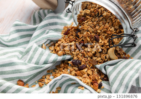 Granola pouring from jar on striped cloth 131896876