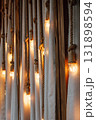 decorative lighting design featuring warm bulbs hanging from ropes against soft fabric backdrop. 131898594