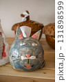 funny handmade ceramic cat sculpture displayed on shelf among other artisan crafts. closeup. 131898599