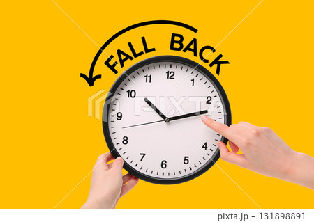 Hand sets clock to 10 o'clock on a bright background 131898891