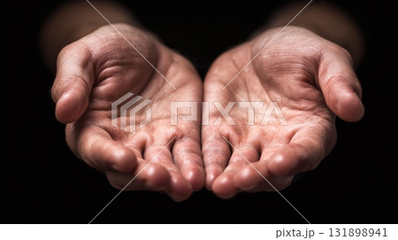 Open Hands: A person presents their open palms, offering a sense of vulnerability, generosity, or anticipation against a dark backdrop. Open Hands: A person presents their open palms, offering a sense of vulnerability, generosity, or anticipation against a dark backdrop. 131898941