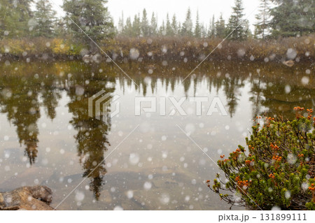 Peaceful waters of little lake in mountains and first snow in autumn. Peaceful waters of little lake in mountains and first snow in autumn. 131899111