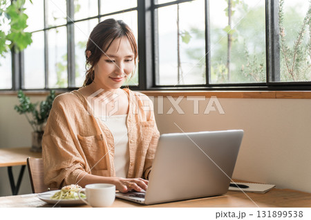 カフェでランチしながらテレワークをする女性 カフェでランチしながらテレワークをする女性 131899538