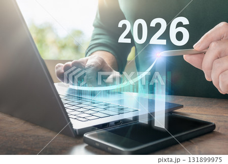 Businessman using laptop with virtual screen showing 2026 and growing graph, concept for digital business growth and investment Businessman using laptop with virtual screen showing 2026 and growing graph, concept for digital business growth and investment 131899975