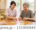 高齢者と介護スタッフが一緒に手作業を楽しむ明るい介護現場 131900849