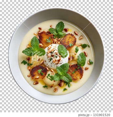 Creamy Celery Root Veloute Soup in Shallow Bowl Topped with Crispy Celery Leaves and Hazelnut Cream 131901520