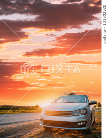 Sedan Car Parking Near Asphalt Country Road In Sunny Sunset. Sunlight Above Road In Sunrise 131902920
