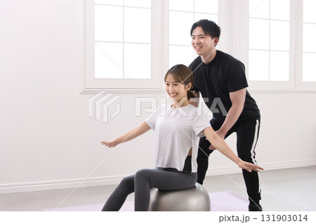 パーソナルトレーナーにレッスンを受ける若い女性 131903014