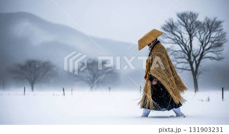 吹雪の中を歩く蓑笠姿の虚無僧 131903231