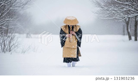 尺八を手に雪道を進む修行僧 131903236