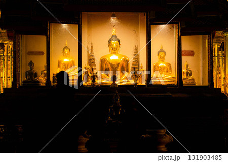 Golden Buddha Statue Illuminated at Night in Thai Temple Golden Buddha Statue Illuminated at Night in Thai Temple 131903485