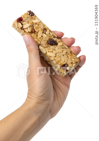 Hands holding healthy oat and nut granola bar, nutritious on-the-go snack isolated on transparent background 131904369