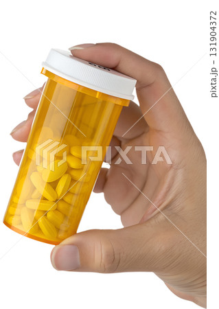 Hand holding yellow prescription pill bottle with white cap, pharmacy and medication adherence concept, isolated on transparent background 131904372