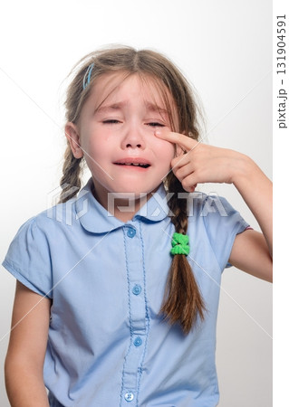 Little girl crying, wiping away tears. Sad, emotional expression. 131904591
