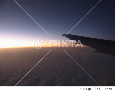 航空機の翼越しに見るフライト中の夕景　 131904676