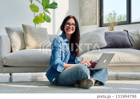 Portrait of young beautiful positive woman with laptop sitting at home Portrait of young beautiful positive woman with laptop sitting at home 131904798
