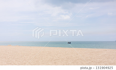 Minimal sandy beach with calm sea and fishing boat under blue sky Minimal sandy beach with calm sea and fishing boat under blue sky 131904925