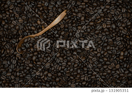 a hint of subtle taste and the ability to enjoy the taste of coffee alone or with friends, these coffee beans are on spoons and scattered on the surface as a background a hint of subtle taste and the ability to enjoy the taste of coffee alone or with friends, these coffee beans are on spoons and scattered on the surface as a background 131905351