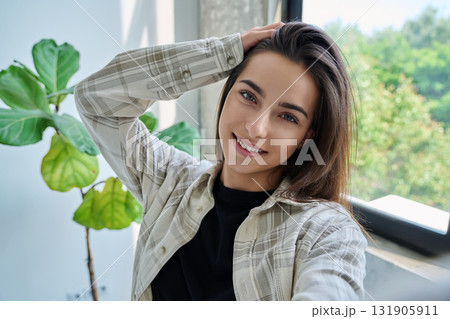 Close-up selfie portrait of teenage female looking at web camera Close-up selfie portrait of teenage female looking at web camera 131905911