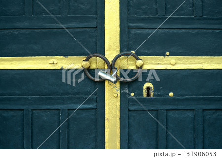 Blue Metal Door Secured with Padlock and Yellow Painted Cross Blue Metal Door Secured with Padlock and Yellow Painted Cross 131906053