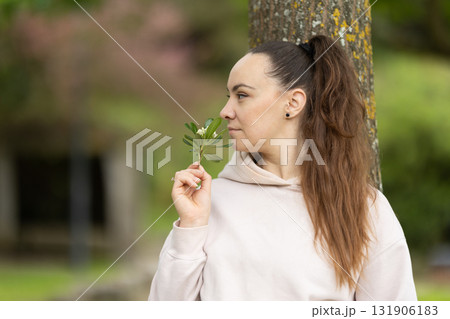 Woman smelling fresh flowers enjoying natural spring essence 131906183