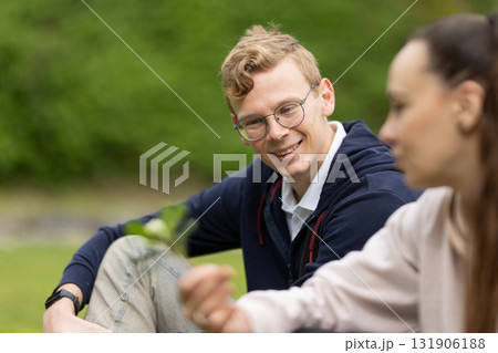 Young man smiling and engaging with a woman outdoors 131906188