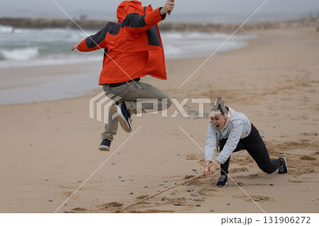 People playing jump rope on a sandy beach People playing jump rope on a sandy beach 131906272