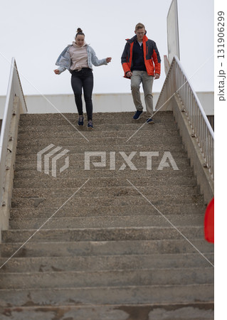 Young people running down concrete stairs outdoors Young people running down concrete stairs outdoors 131906299