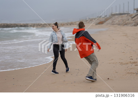 Young couple having fun playing on a beach 131906316