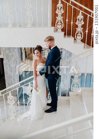 Beautiful and happy bride and groom on a large beautiful staircase. Beautiful and happy bride and groom on a large beautiful staircase. 131907001