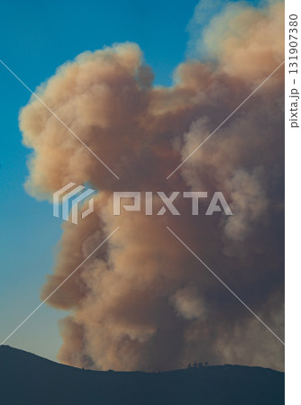 Massive Smoke Plumes Rise Against Clear Blue Sky 131907380