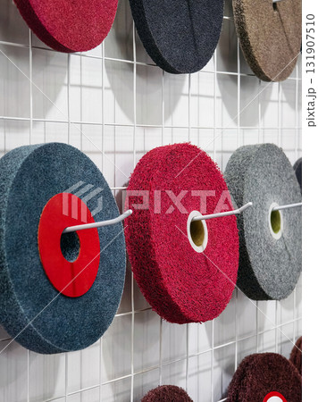 Various colorful felt circles displayed on a wire grid for polishing 131907510