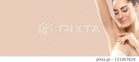 Armpit epilation, lacer hair removal. Young woman holding her arms up and showing clean underarms, depilation  smooth clear skin .Panorama baner With Copy Space. 131907620