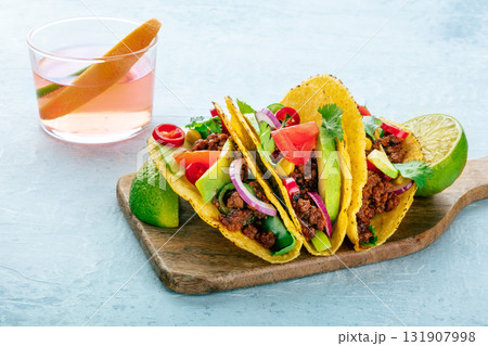 Beef tacos on a wooden board and a Paloma cocktail, Mexican food 131907998