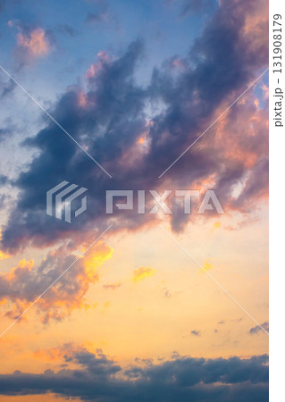 dark cloudscape at sunset. orange-purple clouds on a yellow-blue gradient of sky in evening light. dramatic weather change. wind forecast background. place for copy space. narrow telephoto shot 131908179