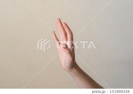 A close-up of a human hand with fingers extended, palm facing forward. The hand is light-skinned with visible details of the fingers and palm. 131908326
